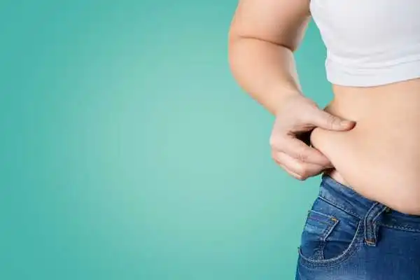 Image of woman pinching her love handles to show weight gain Frimley
